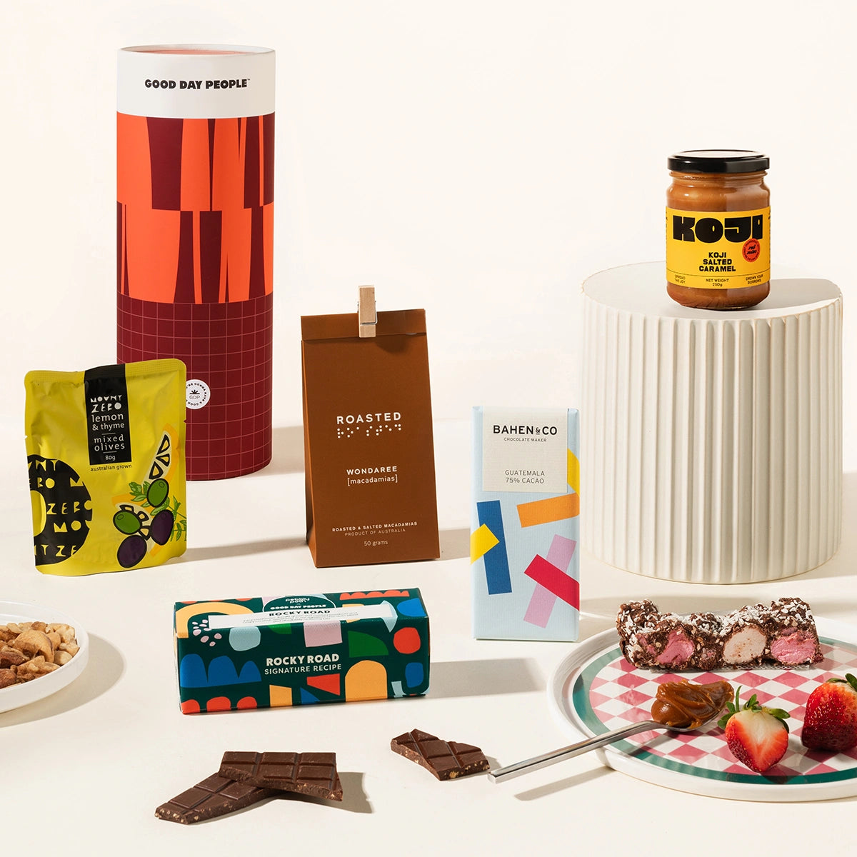 Gourmet gift hamper packaged in a fun canister. The hamper contains olives, Korean BBQ mixed nuts, organic chocolate, rocky road & miso caramel.