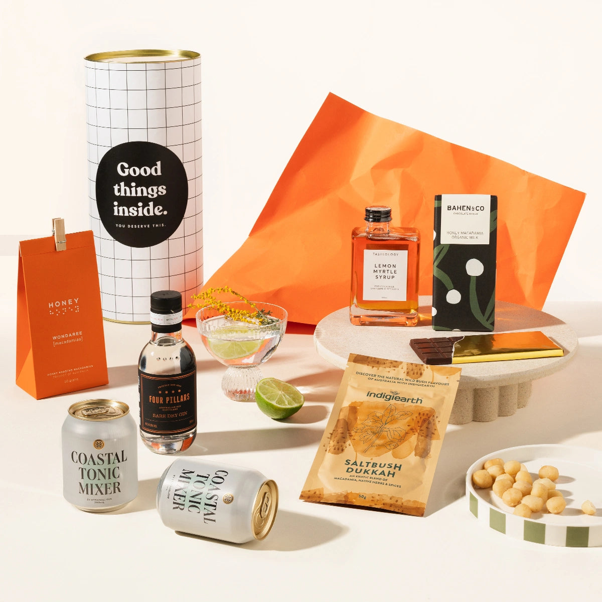Australian-themed gift hamper containing Four Pillars gin, 2 cans of Strangelove coastal tonic, Lemon myrtle syrup, saltbush dukkah, macadamias and a macadamia milk chocolate. Packaged in a fun canister.