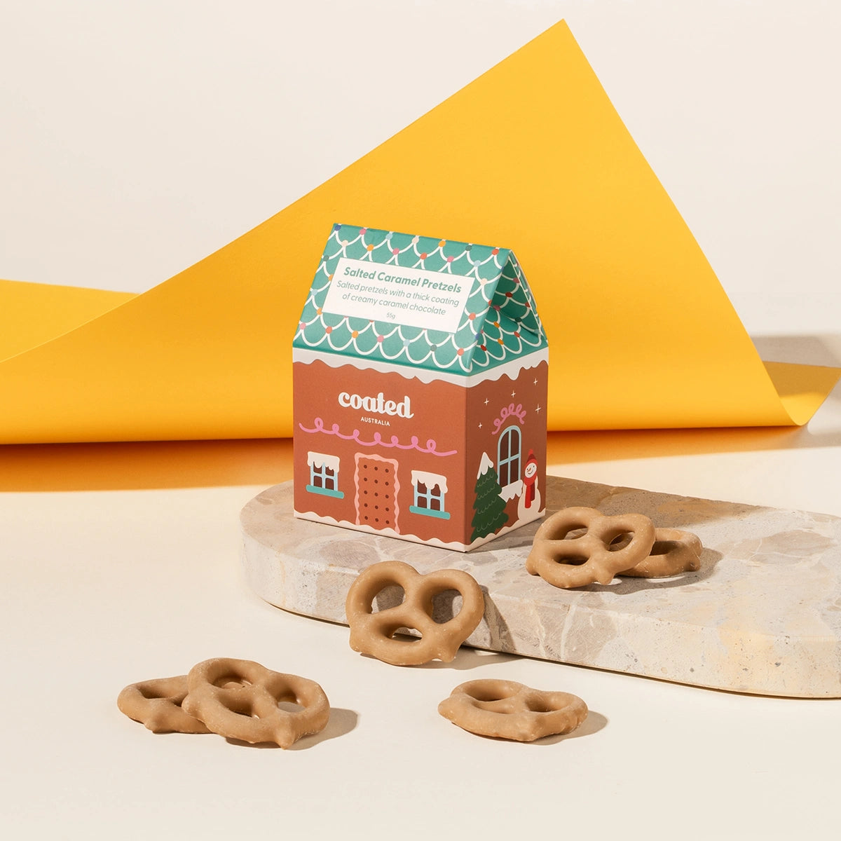 Salted caramel coated pretzels in a gingerbread house packaging