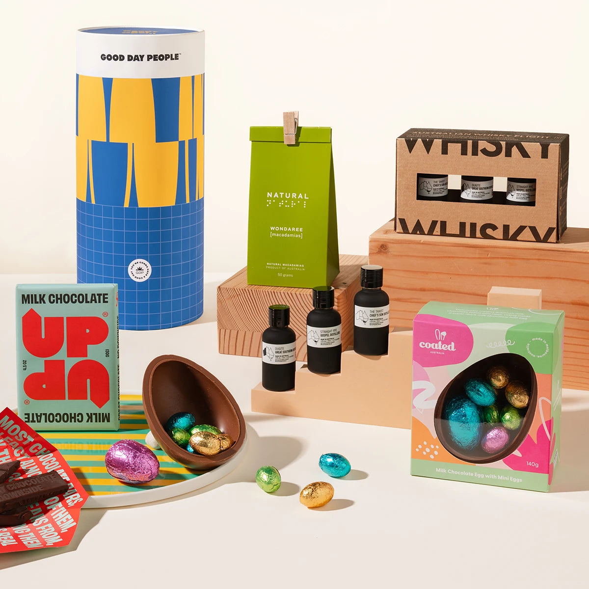 The Easter Edward Gift Hamper with assorted products including a box of 3 mini whisky, a pack of nuts, Easter eggs and chocolate on a white background.