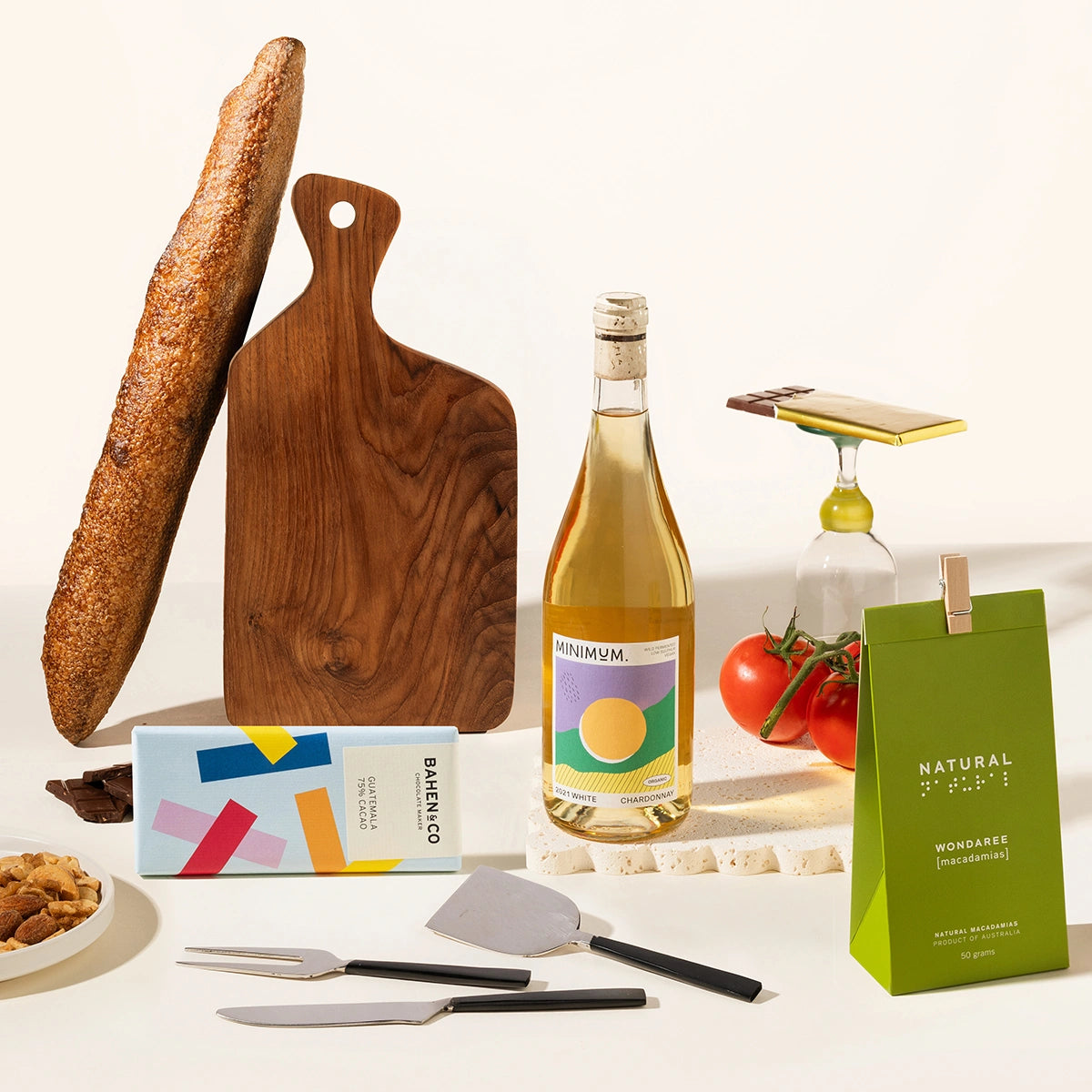 Gourmet gift hamper with a bottle of wine of your choice, a timber serving board, cheese knives (set of 3), chocolate, garlic and truffle mixed nuts.
