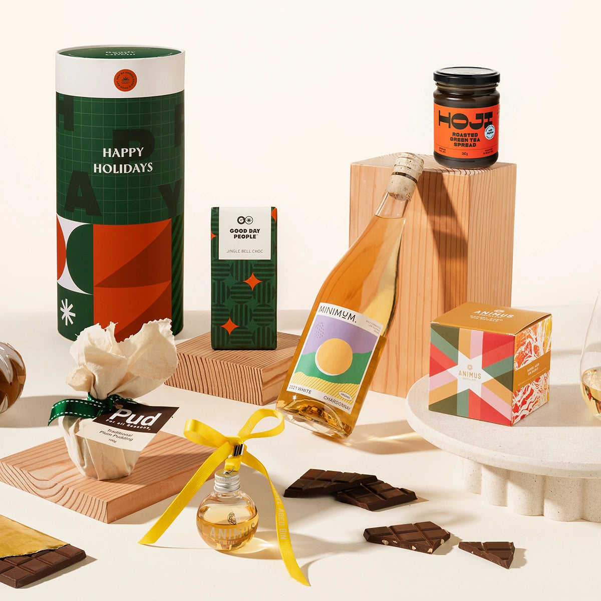 Gourmet Christmas gift set with a bottle of alcohol, chocolates, hojicha spread, christmas pudding, gin bauble