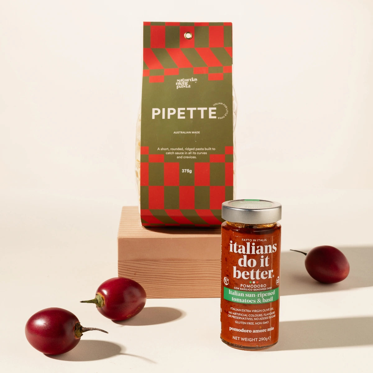 Pomodoro Pasta Suace jar and Pipette pasta with cherry tomatoes on a beige background