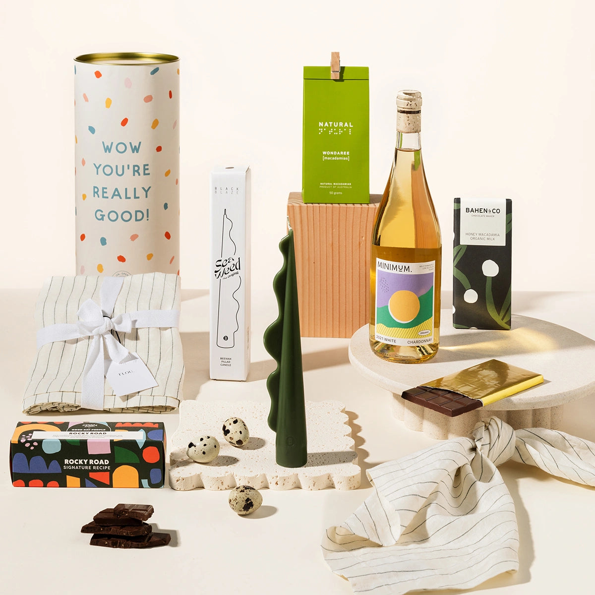 Tasteful Tim gift hamper with linen napkins, sculptural candle, wondaree macadamias, rocky road, wine and chocolate
