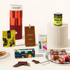 Gourmet gift hamper packaged in a fun canister. The hamper contains olives, Korean BBQ mixed nuts, organic chocolate, rocky road & miso caramel. 