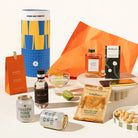 Australian-themed gift hamper containing Four Pillars gin, 2 cans of Strangelove coastal tonic, Lemon myrtle syrup, saltbush dukkah, macadamias and a macadamia milk chocolate. Packaged in a fun canister. 