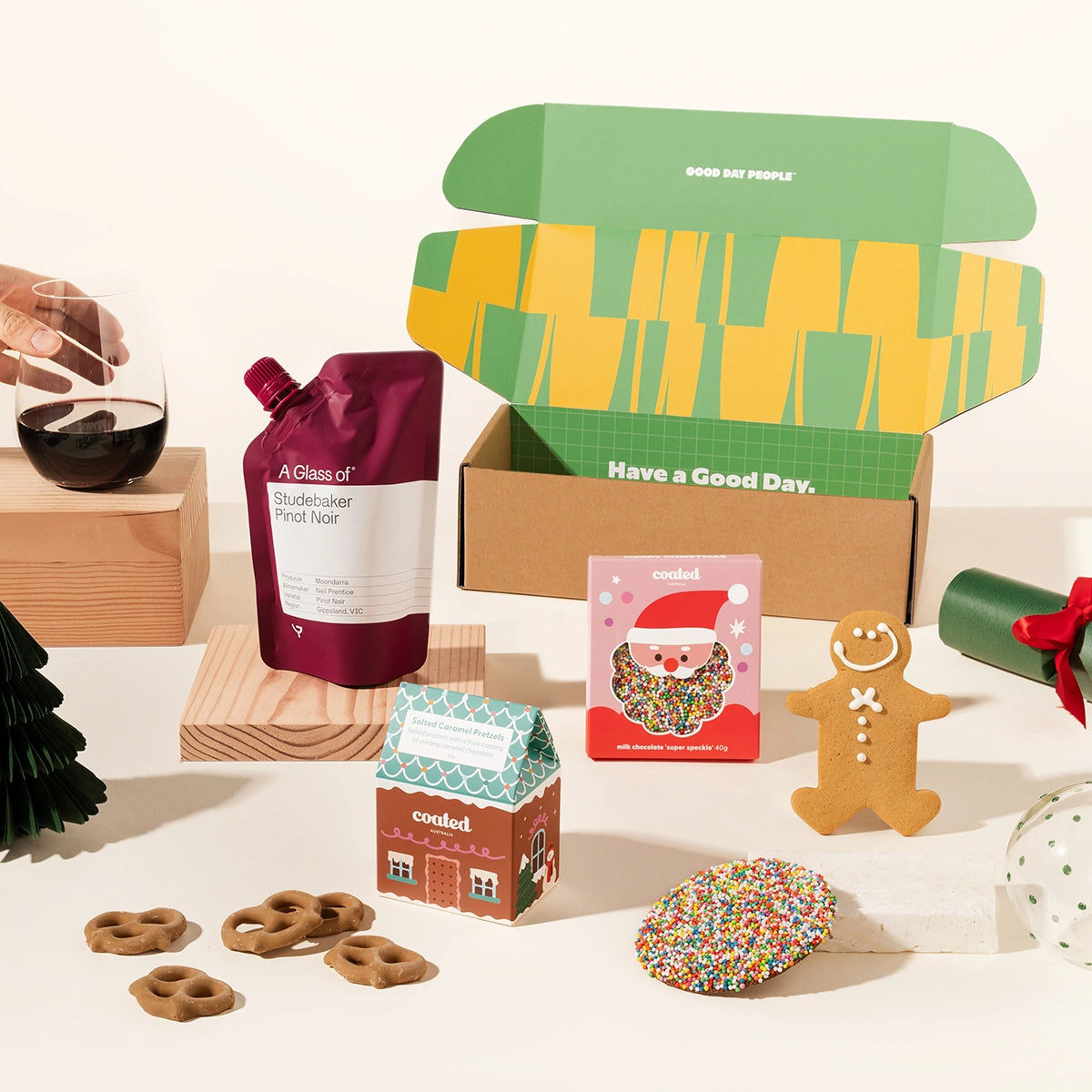 Bauble Bob christmas gift box with a glass of wine, speckle-covered chocolate, salted caramel pretzels and a gingerbread man. Packaged in a designed gift box. 