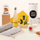 Summer-inspired gift hamper with Zoncello limoncello spritz, Standard procedure sunscreen, olives, a turkish beach towel and Korean BBQ mixed nuts, packaged in a fun canister.