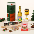 Christmas gift hamper including a bottle of wine, a jar of miso caramel, and a box of chocolate coated marshmallows and a speckled milk chocolate. 
