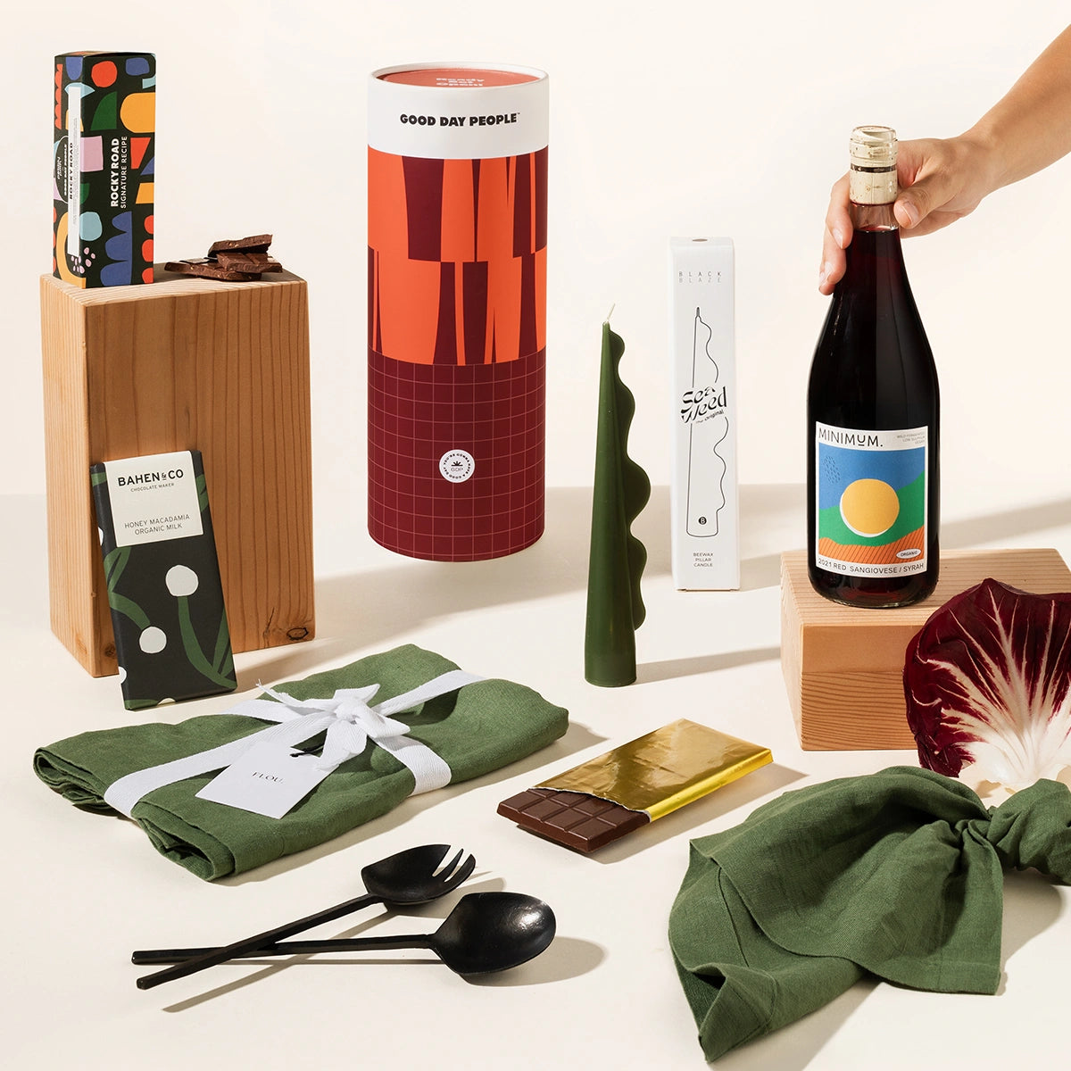 Classy gift hamper with a set of 4 linen napkins, your wine of choice, cast iron salad servers, a decorative sculptural candle, organic chocolate and rocky road.