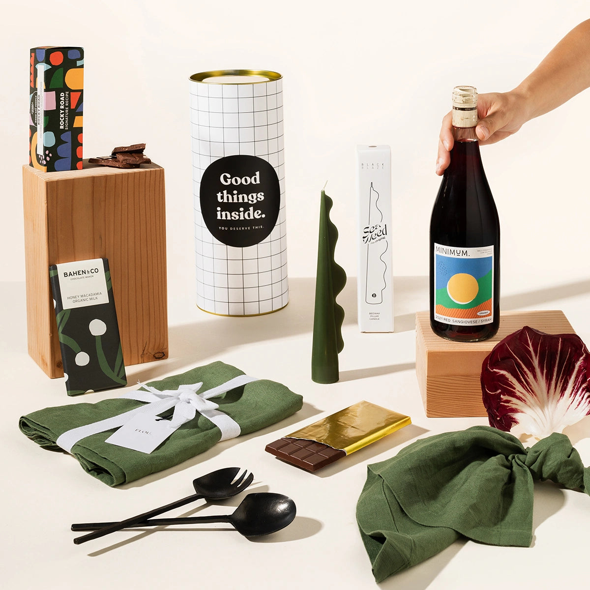 Classy gift hamper with a set of 4 linen napkins, your wine of choice, cast iron salad servers, a decorative sculptural candle, organic chocolate and rocky road.