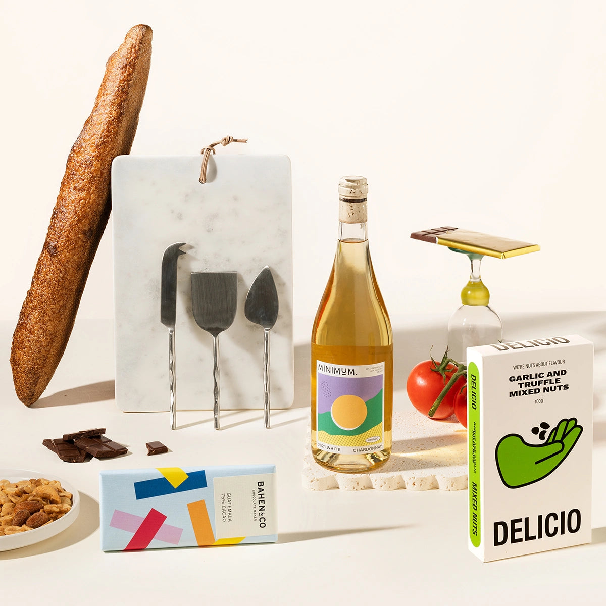 Gourmet gift hamper with a bottle of wine of your choice, a marble serving board, cheese knives (set of 3), chocolate, garlic and truffle mixed nuts. 