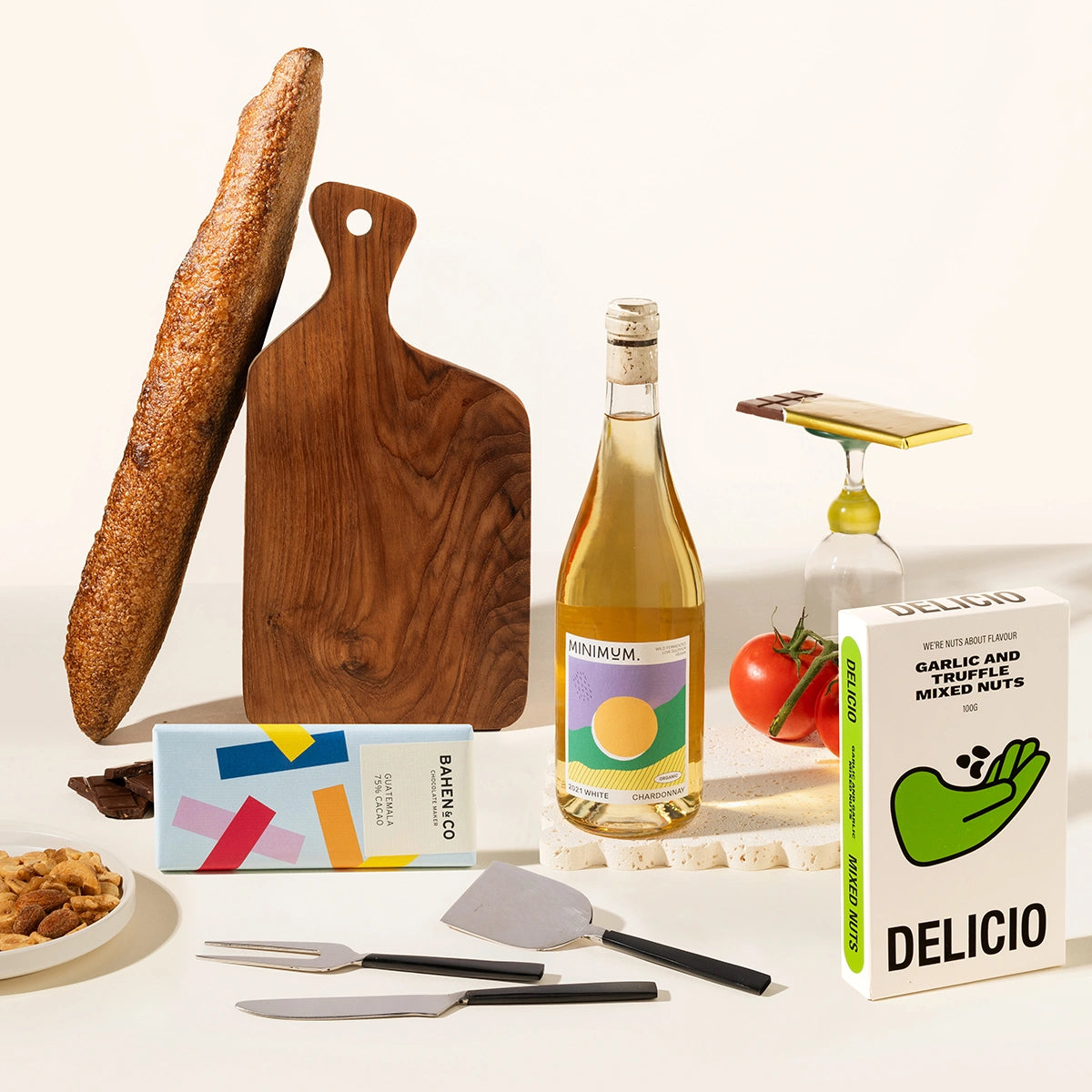 Gourmet gift hamper with a bottle of wine of your choice, a timber serving board, cheese knives (set of 3), chocolate, garlic and truffle mixed nuts. 