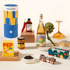 Gourmet Greg Gift Box with wine, chilli sauce, miso caramel, gourmet pepper and rocky road. Packaged in a design-forward canister.