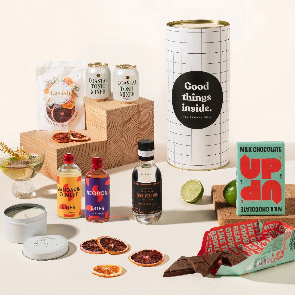 Gin & tonic gift hamper with Four Pillars gin, 2 cans of coastal tonic mixers, Lavish blood orange garnish, a tinned candle, and Up-Up chocolate. Packaged in a designed canister.