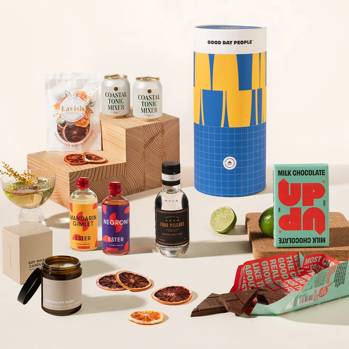 Gin & tonic gift hamper with Four Pillars gin, 2 cans of coastal tonic mixers, Lavish blood orange garnish, a tinned candle, and Up-Up chocolate. Packaged in a designed canister.