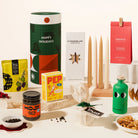 Luxurious Christmas Hamper with 4 tapered candles, nuts, hojicha spread, greek olive oil, christmas pudding, gourmet pepper & mount zero olives. Packaged in an epic, designed canister. Trendy & Bougie Christmas gift.