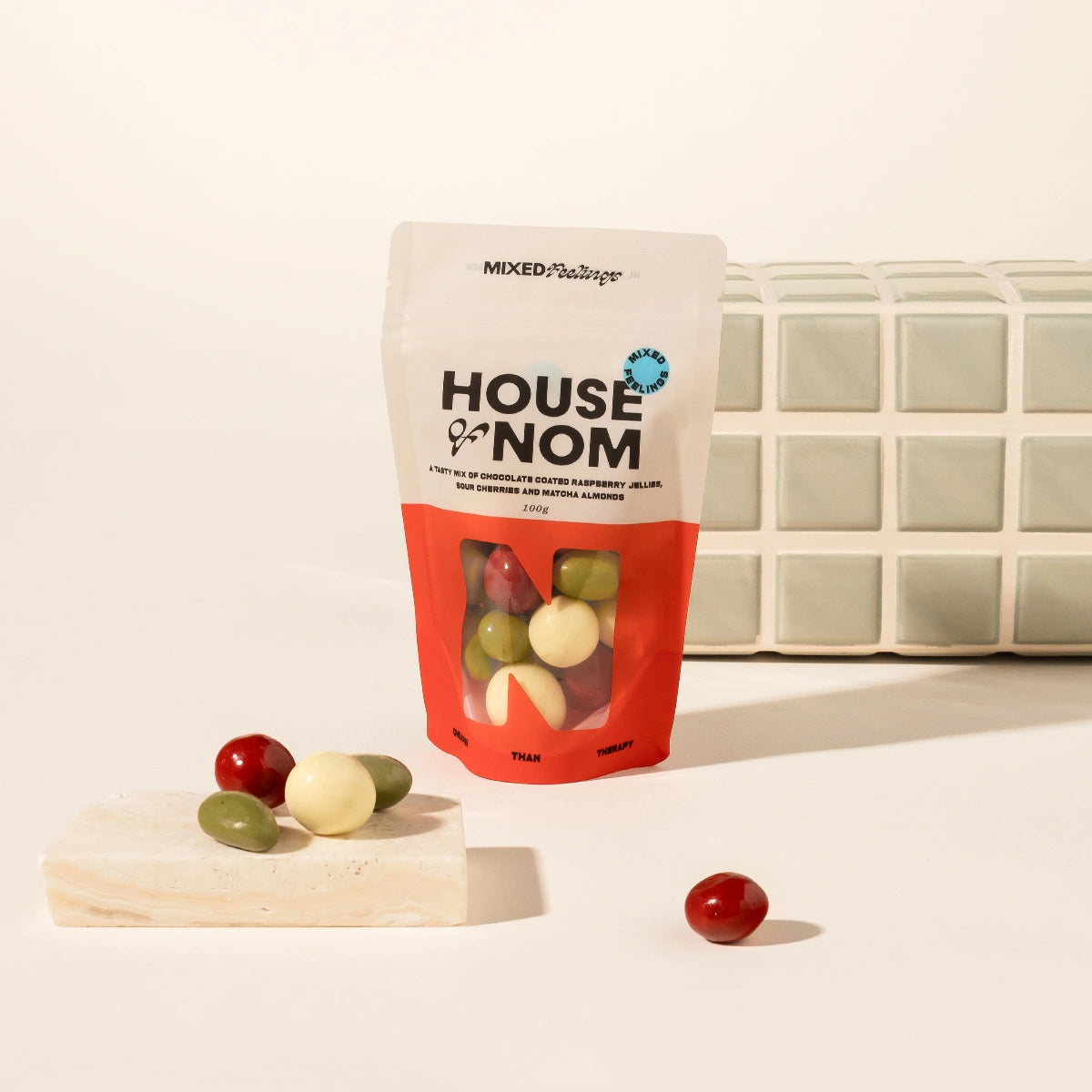 A stand-up pouch of Mixed Feelings chocolate coated nuts by House of Nom. Mixed choc nuts coated with matcha, raspberry and white choc.