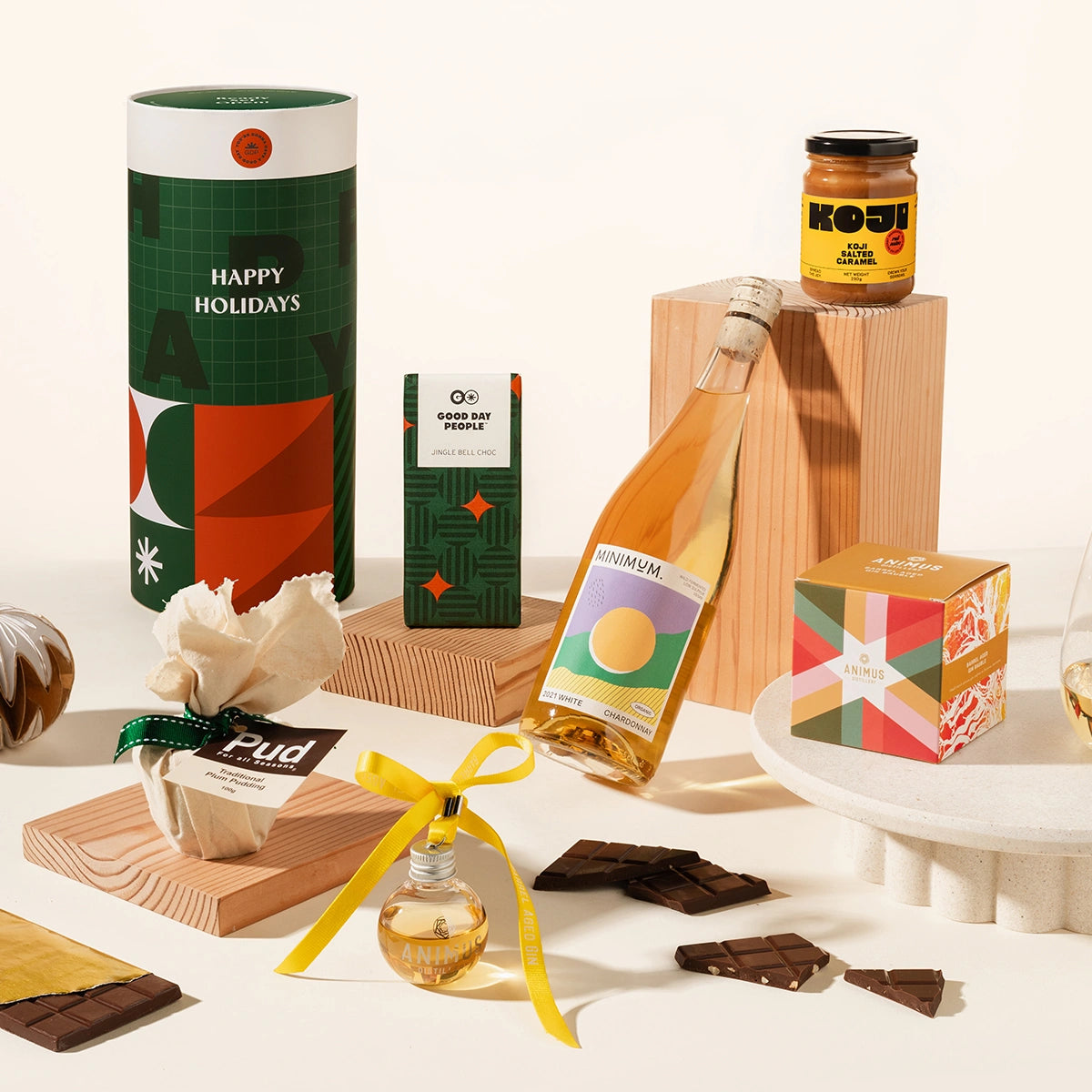 Gourmet Christmas gift set with a bottle of alcohol, chocolates, miso caramel, christmas pudding, gin bauble