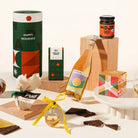 Gourmet Christmas gift set with a bottle of alcohol, chocolates, hojicha spread, christmas pudding, gin bauble