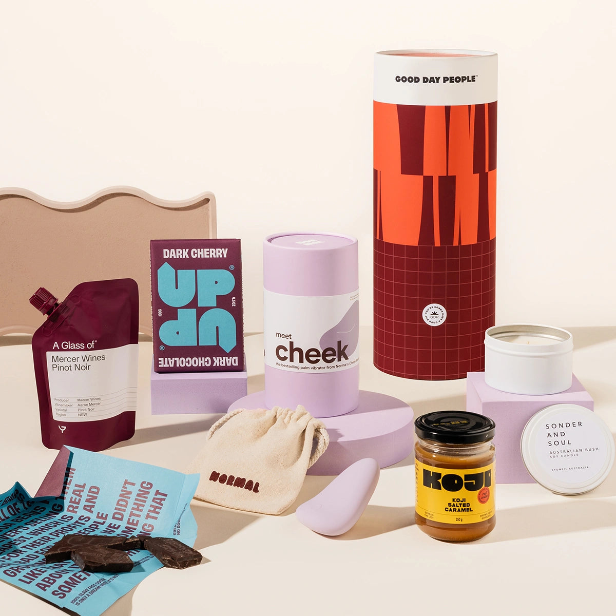 Pamper hamper with a Normal Cheek palm vibrator sex toy, chocolate, wine, miso caramel and candle. Packaged in a designed canister. 