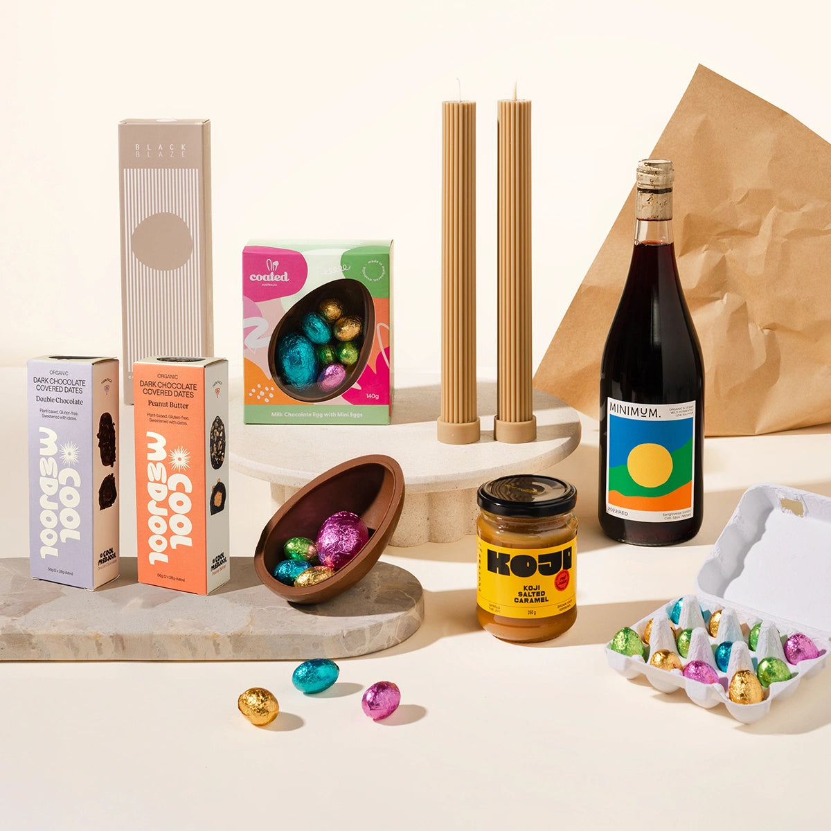 Munching Matilda Gift Hamper with assorted Easter-themed products including chocolate eggs, a bottle of wine, and a jar of Koji on a light background.