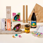 Munching Matilda Gift Hamper with assorted Easter-themed products including chocolate eggs, a bottle of wine, and a jar of Koji on a light background.
