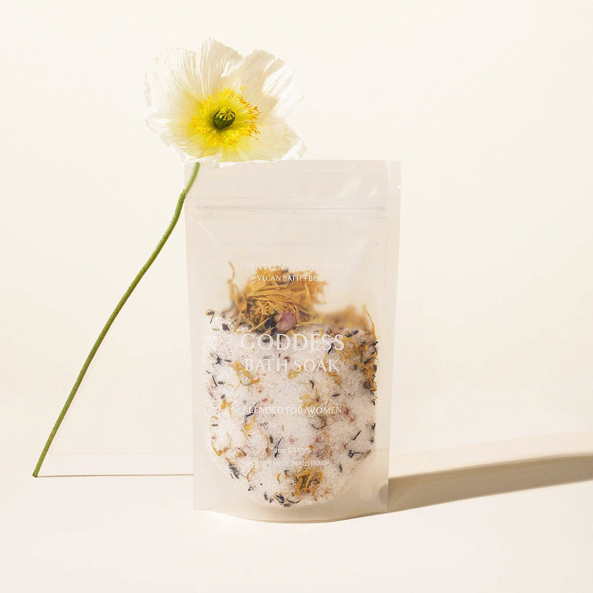 Bath salts with a flower petals on a light background