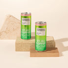 2 green cans of st ali strawberry iced matcha styled on timber and masonry blocks